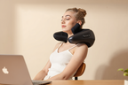 Person seated in a car using the shiatsu massage pillow