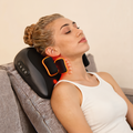 Woman sitting with the shiatsu neck and shoulder massage pillow